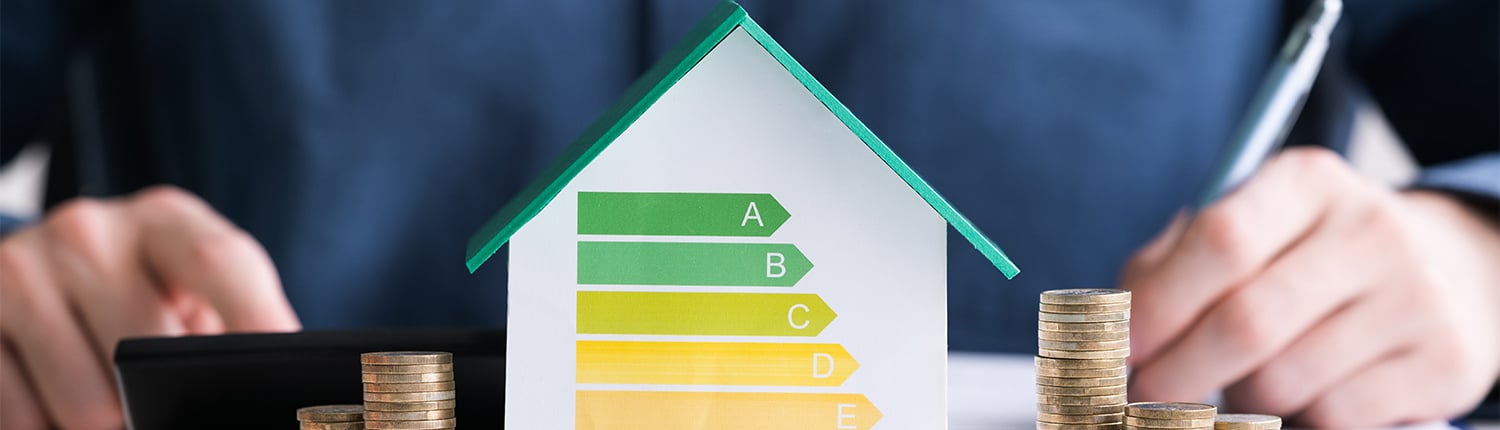Rechnung mit Euro-Münzen und Energieeffizienzklasse auf dem Schreibtisch